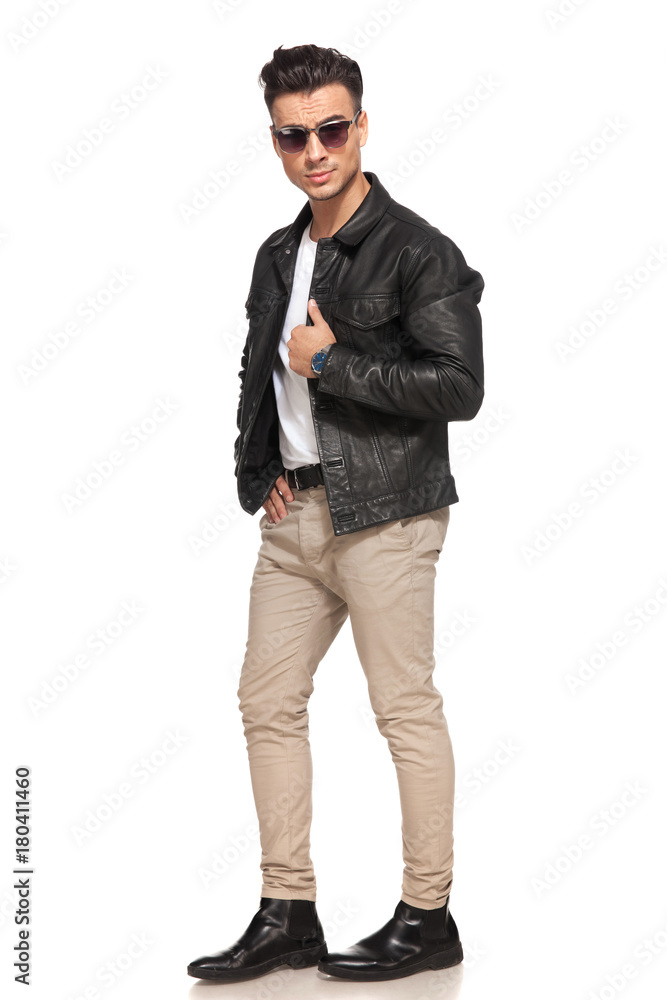serious yong man holding jacket's collar and wear sunglasses serious yong man holding jacket's collar and wear sunglasses
