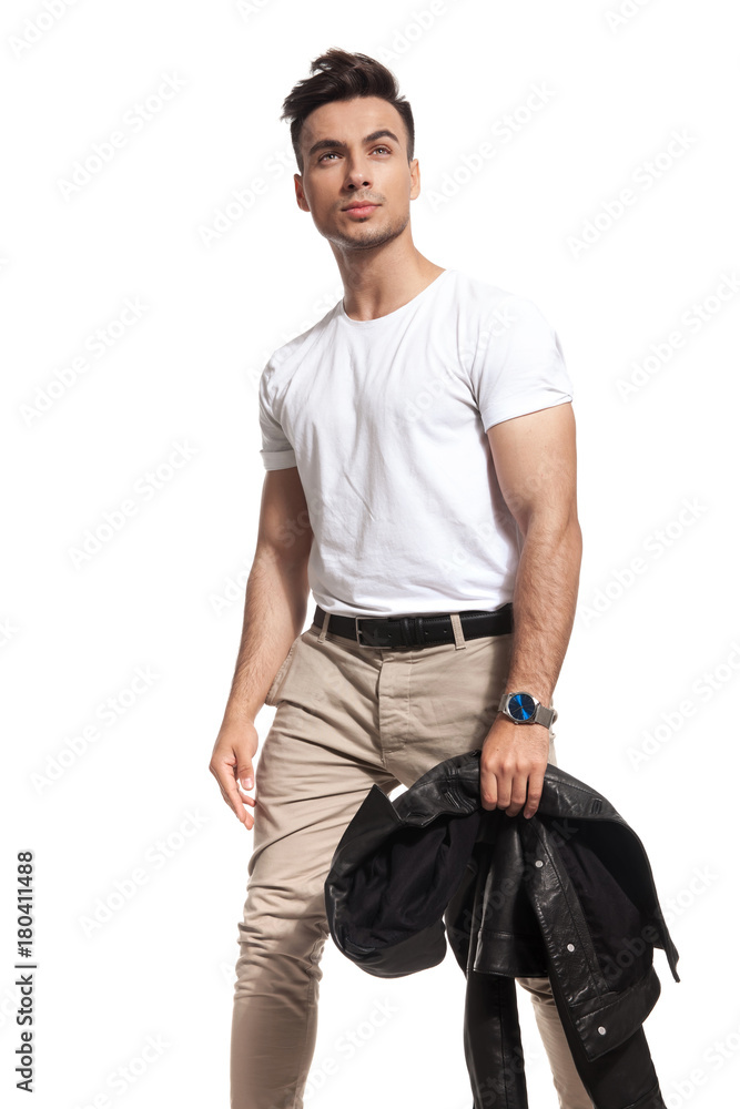 young casual man holding jacket looks up young casual man holding jacket looks up
