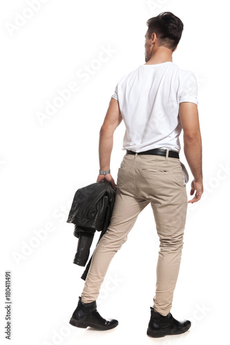 back view of sexy man holding jacket and walks