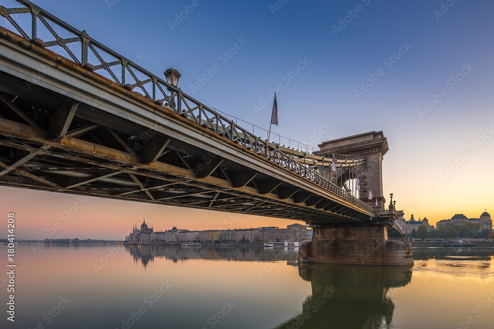 Obraz premium Budapest, Hungary - Beautiful golden sunrise at Szechenyi Chain Bridge with Hungarian Parliament at background. Clear blue sky