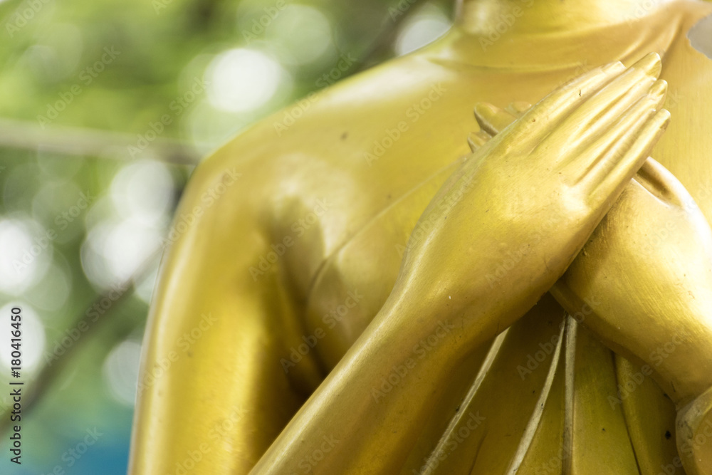 Obraz premium Closeup hands of buddha statue touching the heart on chest