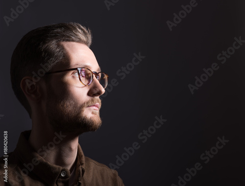 Portrait of a man looking at the light from the darkness