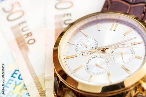 Wrist watch with euro. Close up. Business concept. Financial background.
