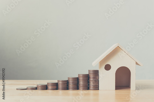Property investment and house mortgage financial concept, Money coin stack with wooden house photo