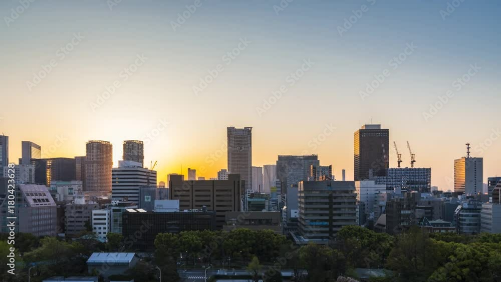 Tokyo skyline sunrise with business skyscrapers in Minato district, Japan. Time lapse with sun rays Tokyo skyline sunrise with business skyscrapers in Minato district, Japan. Time lapse with sun rays