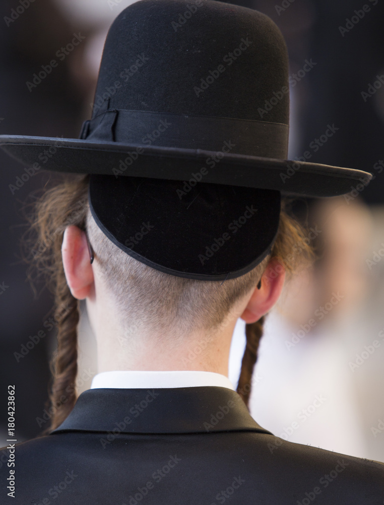 from the back, a man with glasses, traditional orthodox Jewish clothes
