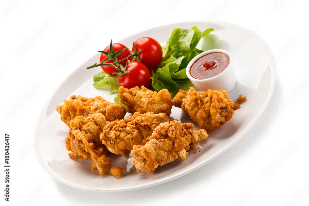 Fried chicken nuggets with vegetables on white background Fried chicken nuggets with vegetables on white background