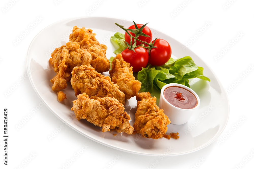Fried chicken nuggets with vegetables on white background Fried chicken nuggets with vegetables on white background