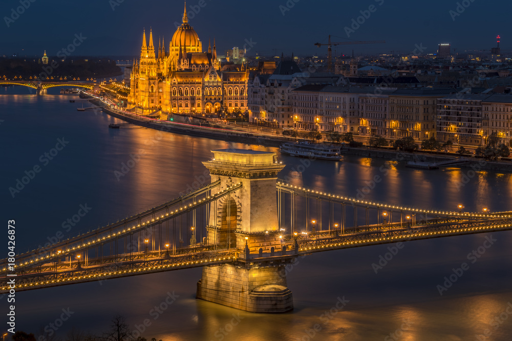 The Chain Bridge with the Hungarian Parliament in the background with the lights on.