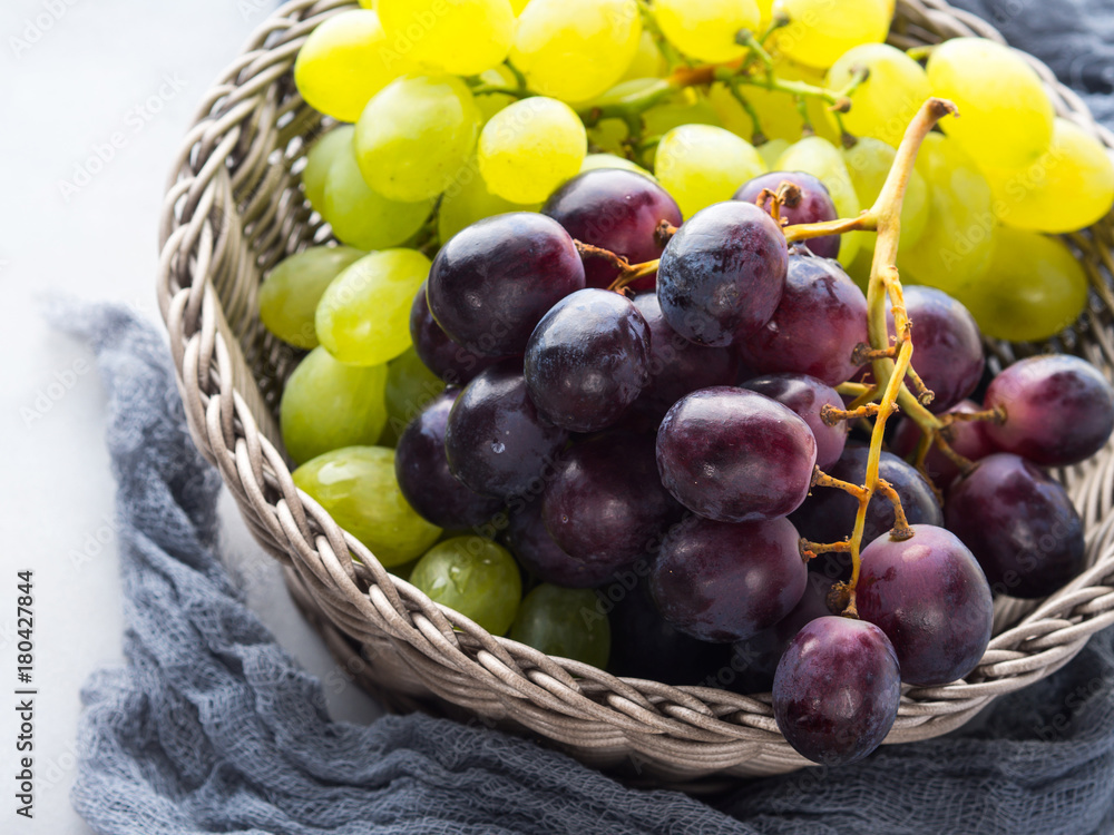 White and dark grapes in a basket on gray. Abstract minimal fruit still life White and dark grapes in a basket on gray. Abstract minimal fruit still life