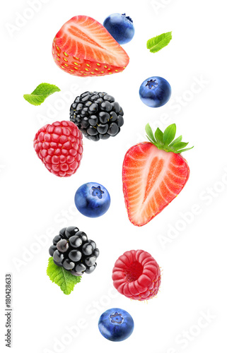 Isolated fresh berries in the air. Falling blackberry, raspberry, blueberry, strawberry fruits and mint leaves isolated on white background with clipping path