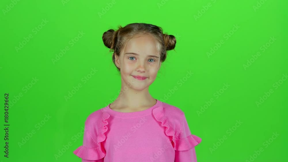Baby smiles and looks into the distance, covering her face with her hands. Green screen. Slow motion Baby smiles and looks into the distance, covering her face with her hands. Green screen. Slow motion