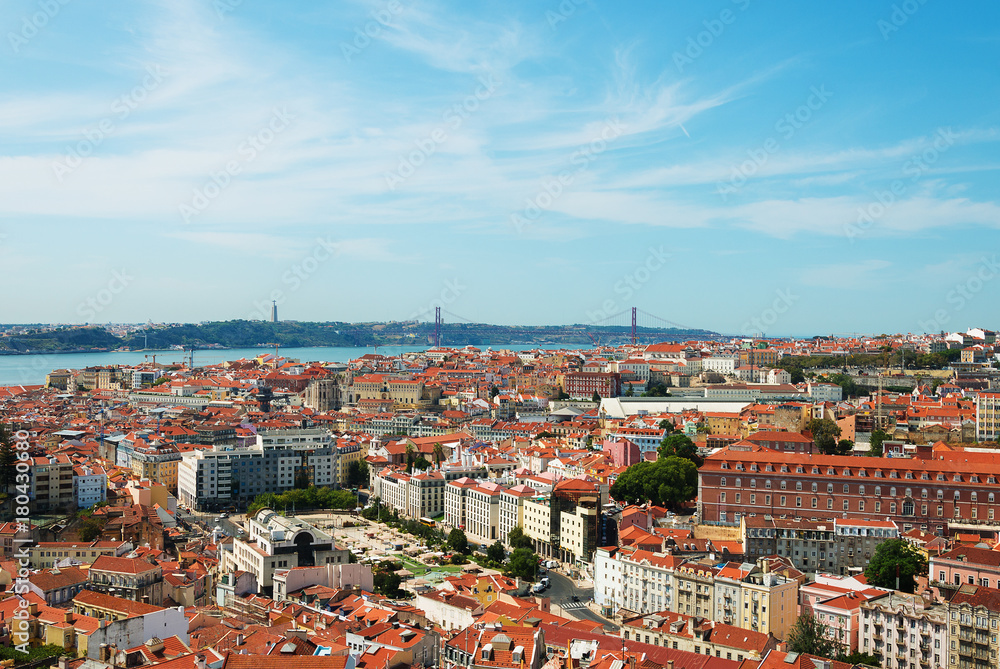 Alfama downtown and the 25 April Bridge in Lisbon, Portugal.