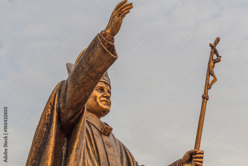 Obraz premium Ancient brass sculpture of Pope, the bishop of Rome with golden sunlight glare on the statue. With selective focus on the subject.
