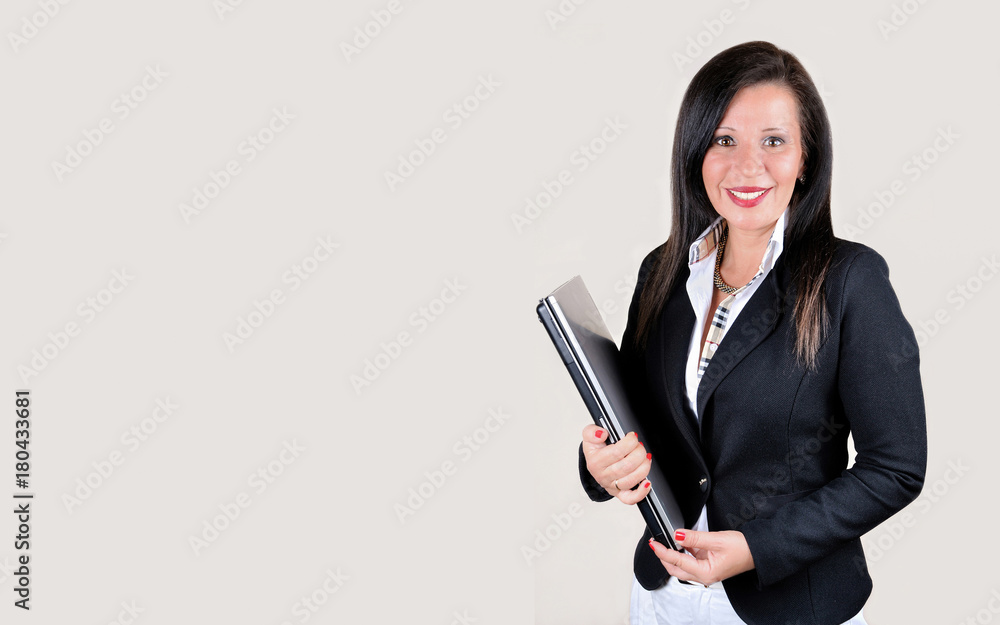 Smiling businesswoman with laptop isolated on the gray background. Copy space on the left side. Smiling businesswoman with laptop isolated on the gray background. Copy space on the left side.