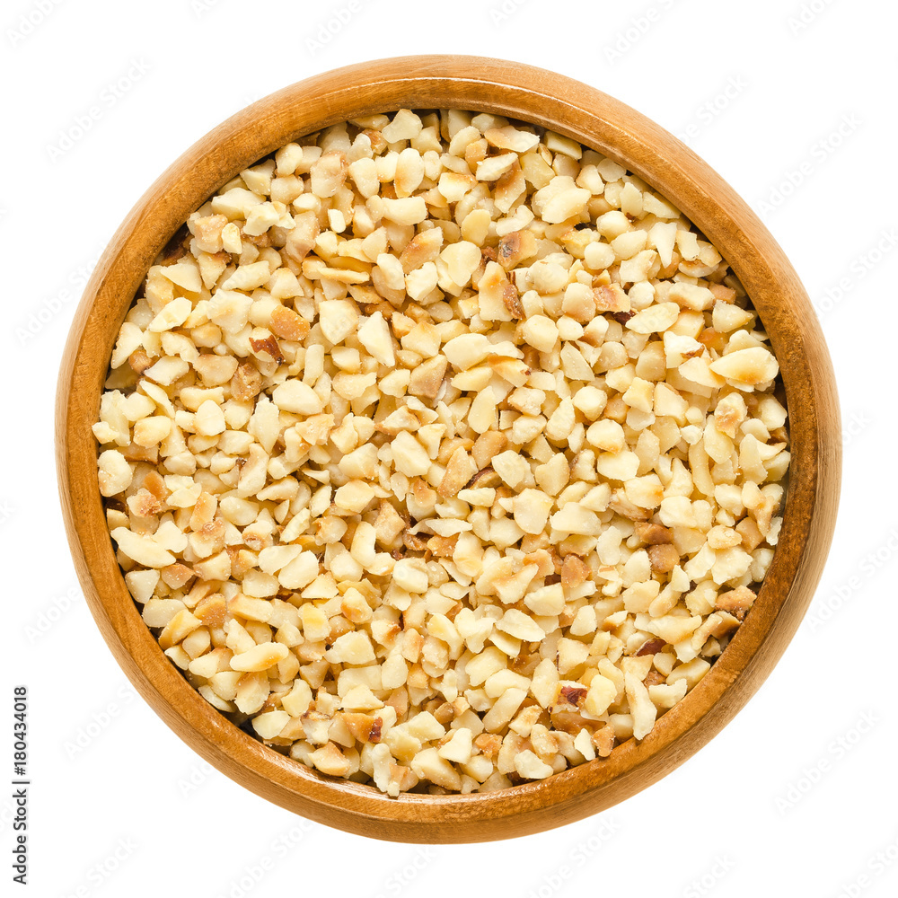 Hazelnut kernels, roughly chopped, in wooden bowl. Edible dried shelled seeds of Corylus avellana, also called cobnut or filbert nut. Isolated macro food photo close up from above on white background. Hazelnut kernels, roughly chopped, in wooden bowl. Edible dried shelled seeds of Corylus avellana, also called cobnut or filbert nut. Isolated macro food photo close up from above on white background.