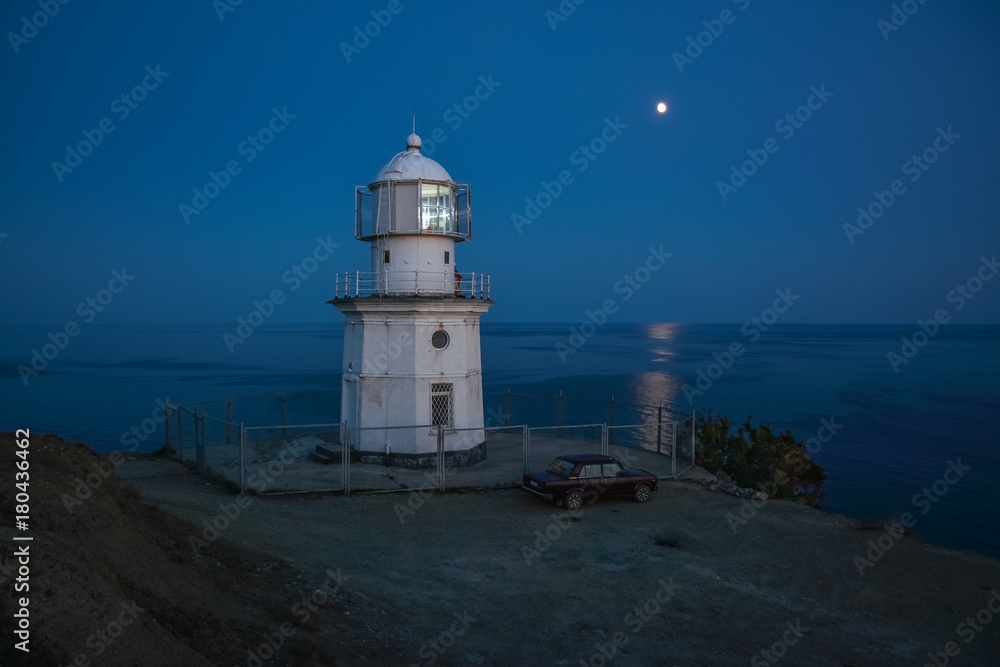 Night sea landscape - lighthouse in the light of the moon