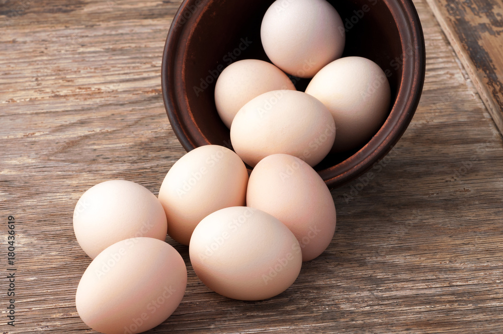 chicken eggs in a bowl on wooden background chicken eggs in a bowl on wooden background