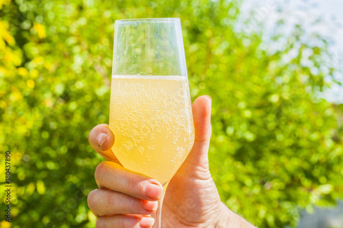 apple cider in glass holding in hand summer outdoors photo