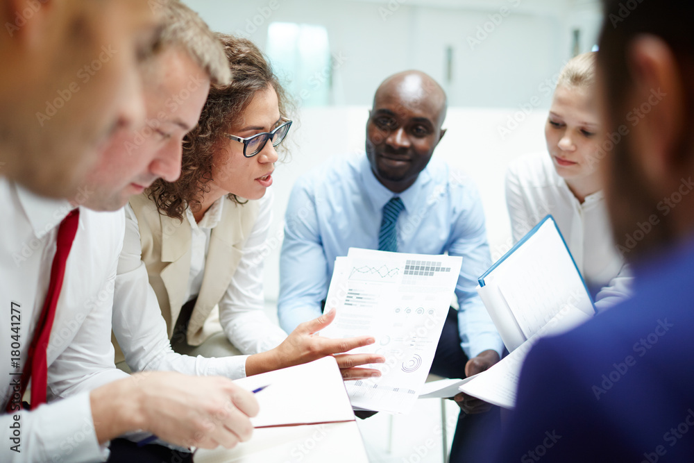 Fototapeta premium Group of accountants discussing papers and financial statistics at meeting