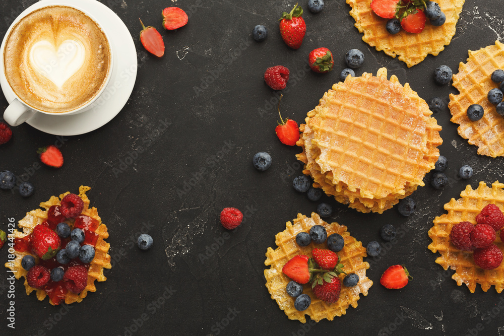 Round belgium waffles with berries, tasty breakfast on black background Round belgium waffles with berries, tasty breakfast on black background