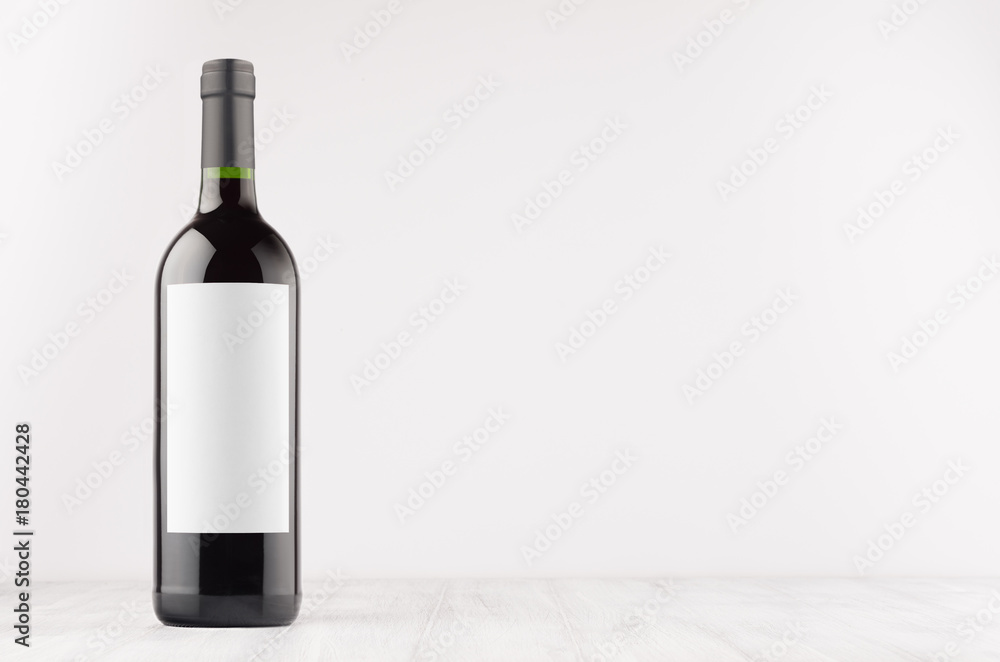 Dark wine bottle with blank white label on white wooden board, mock up. Template for advertising, design, branding identity. Dark wine bottle with blank white label on white wooden board, mock up. Template for advertising, design, branding identity.
