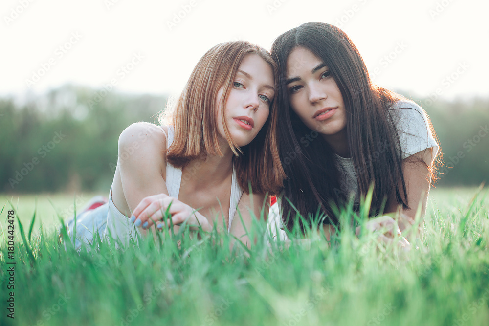 Two beautiful young woman lie on the grass Two beautiful young woman lie on the grass