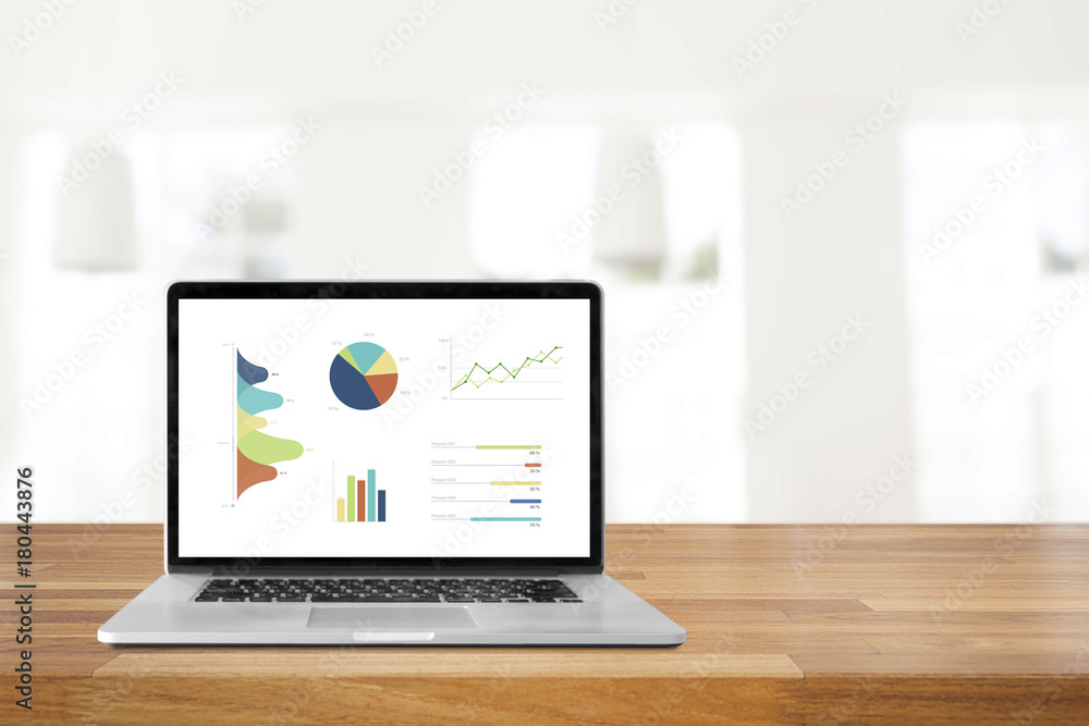 Laptop on wooden table showing charts and graph against office background ,Analysis Business Accounting, Statistics Concept. Laptop on wooden table showing charts and graph against office background ,Analysis Business Accounting, Statistics Concept.