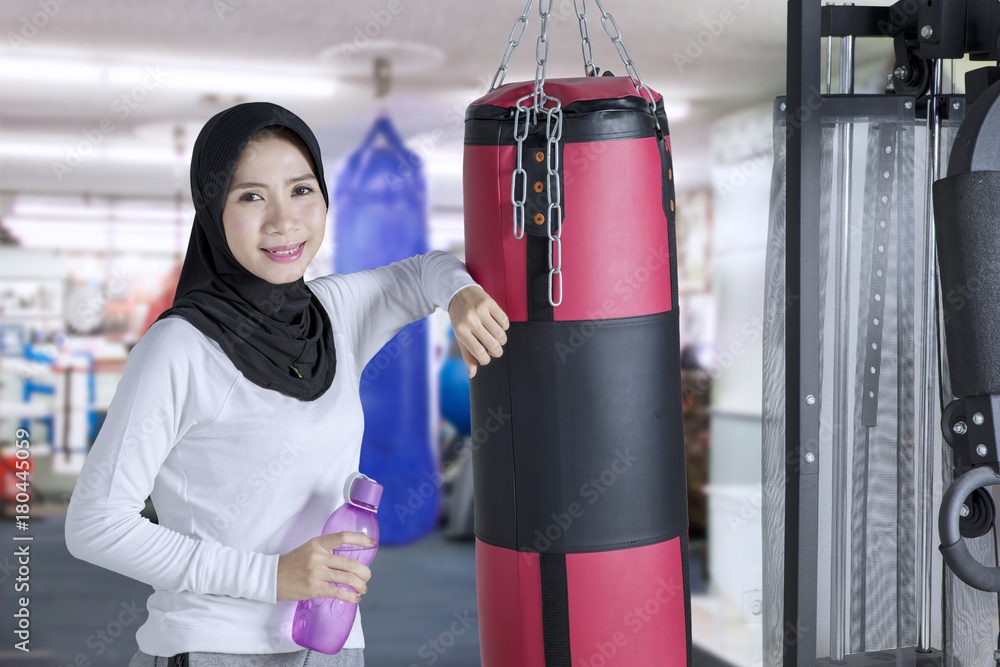Female muslim and boxing sack