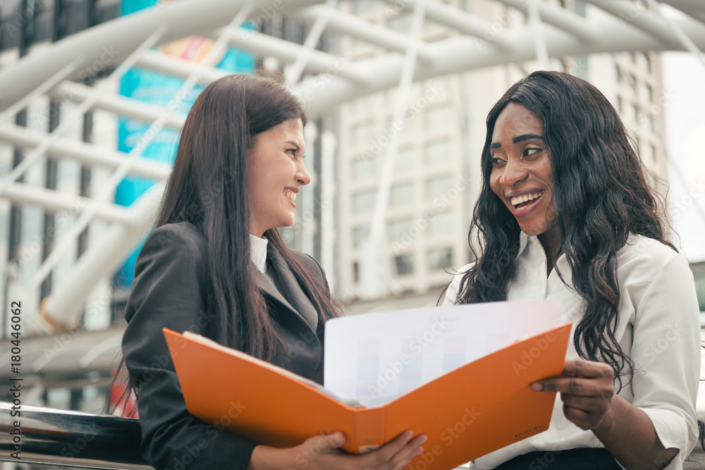 Work talking between black girl and Asian girl Work talking between black girl and Asian girl
