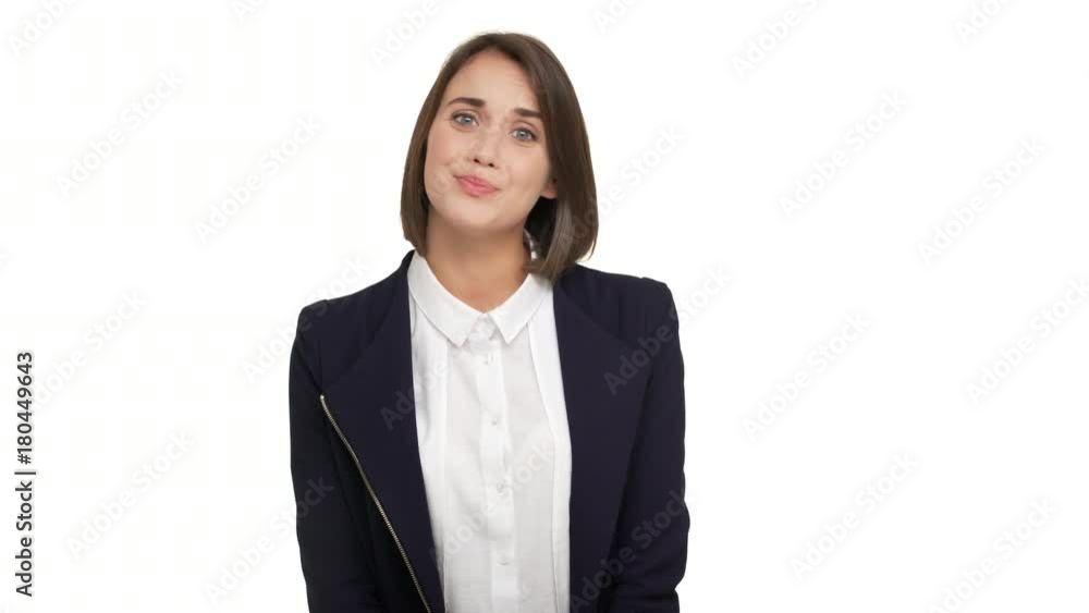 portrait of embarrassing young woman with short dark hair in formal wear smiling nervously biting lips regretting about something meaning it's not my fault over white background. Concept of emotions portrait of embarrassing young woman with short dark hair in formal wear smiling nervously biting lips regretting about something meaning it's not my fault over white background. Concept of emotions