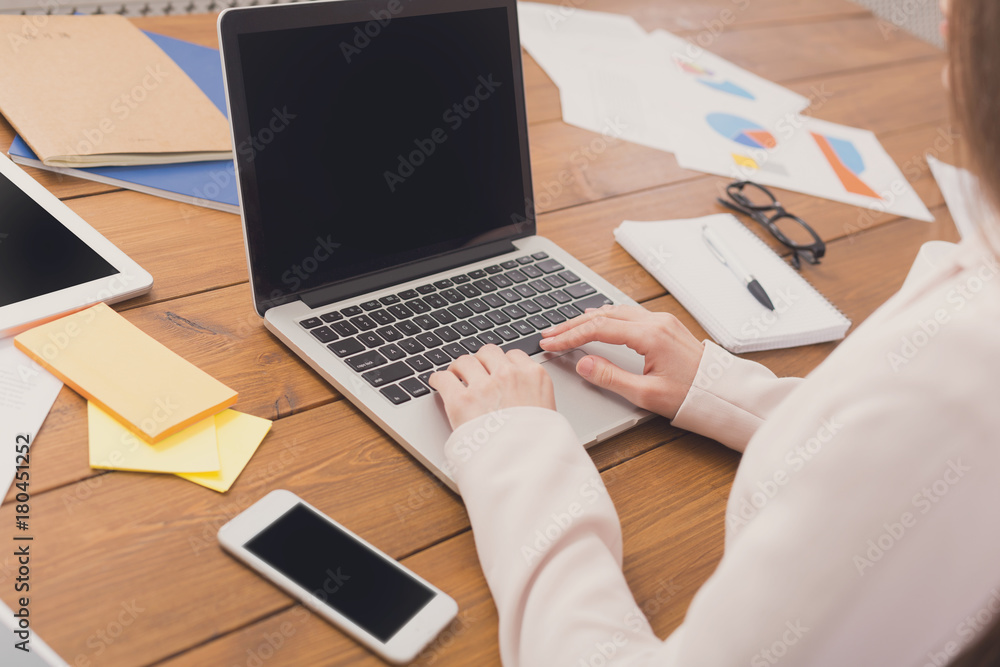 Business woman typing on laptop with blank screen Business woman typing on laptop with blank screen
