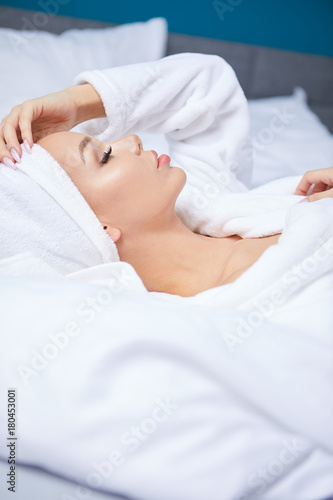 A woman in a bathrobe and a towel on her head