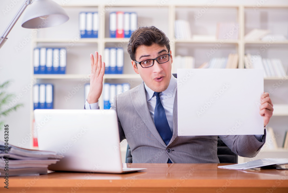 Businessman in office holding a blank message board Businessman in office holding a blank message board