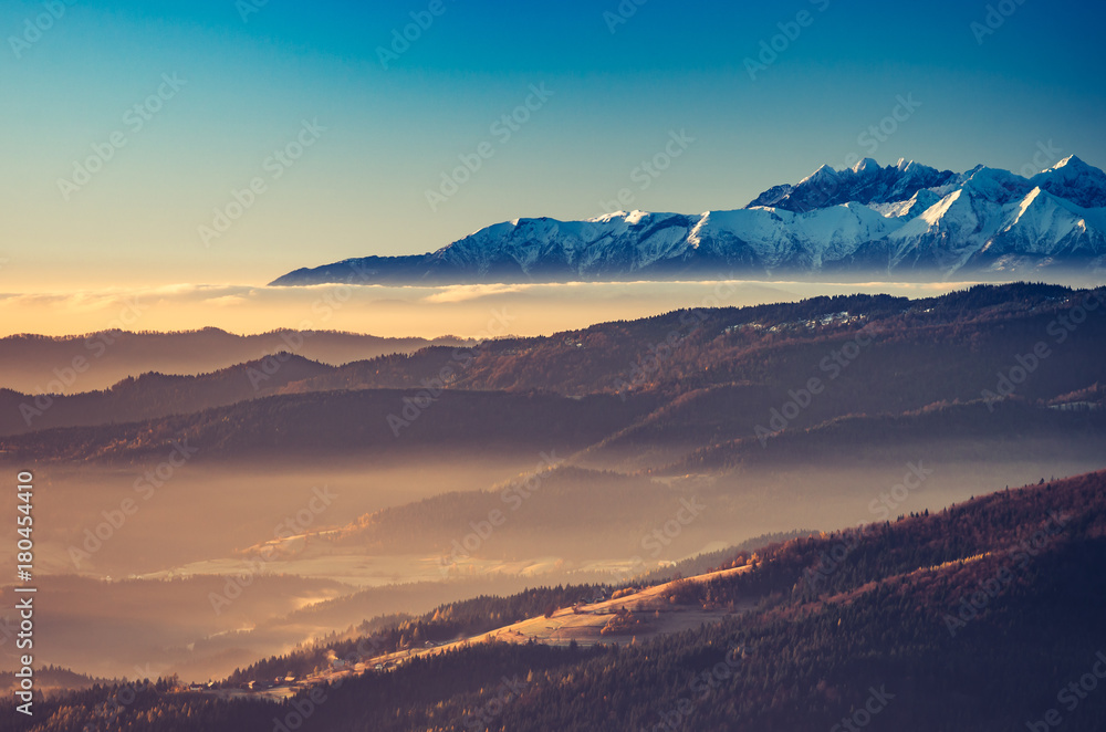 Obraz premium panorama over misty Gorce to snowy Tatra mountains in the morning, Poland landscape