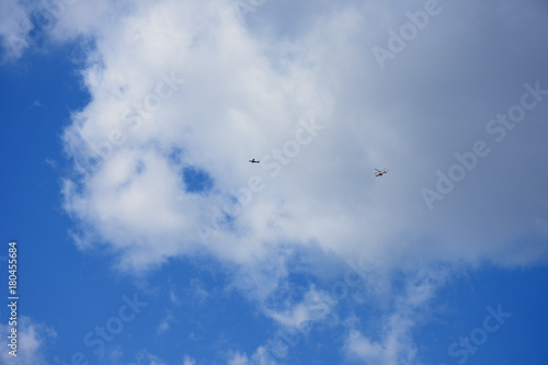 飛行機とヘリコプター・青空と雲「空想・雲のモンスターたち」（背後に存在するもの、背後に隠れた、何者かの存在、飛び交うなどのイメージ）