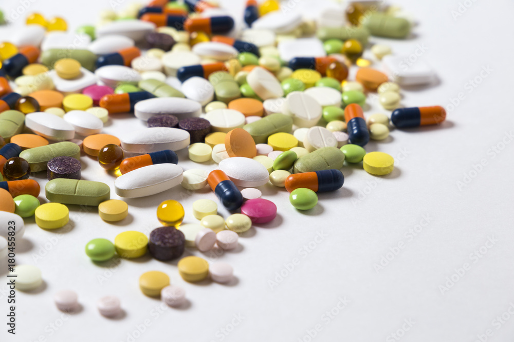 a lot of multicolored pills and capsules on the white background with copy space a lot of multicolored pills and capsules on the white background with copy space