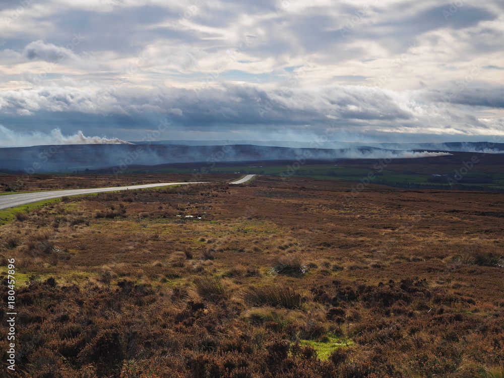 Controlled burning of the heather in the autumn under a brooding sky in the North York Moors National Park, Yorkshire, UK Controlled burning of the heather in the autumn under a brooding sky in the North York Moors National Park, Yorkshire, UK