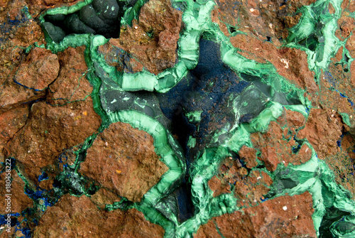 background, texture: brown bumpy surface of a block of copper ore with veins and geodes of malachite and azurite.. photo