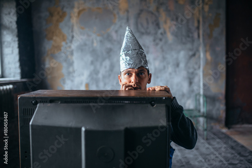 Afraid man in aluminum foil cap watch TV, UFO