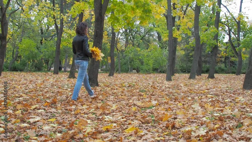 A young woman is walking in the autumn park. A young woman is walking in the autumn park.