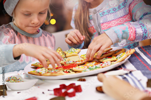 Happy little sisters preparing Christmas biscuits