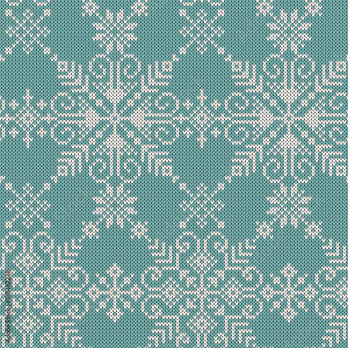 Seamless knitted pattern of snowflakes.Knitted texture