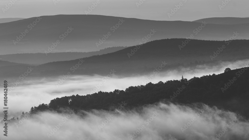 Early morning fog and mist between rolling hills in the Scottish Highlands