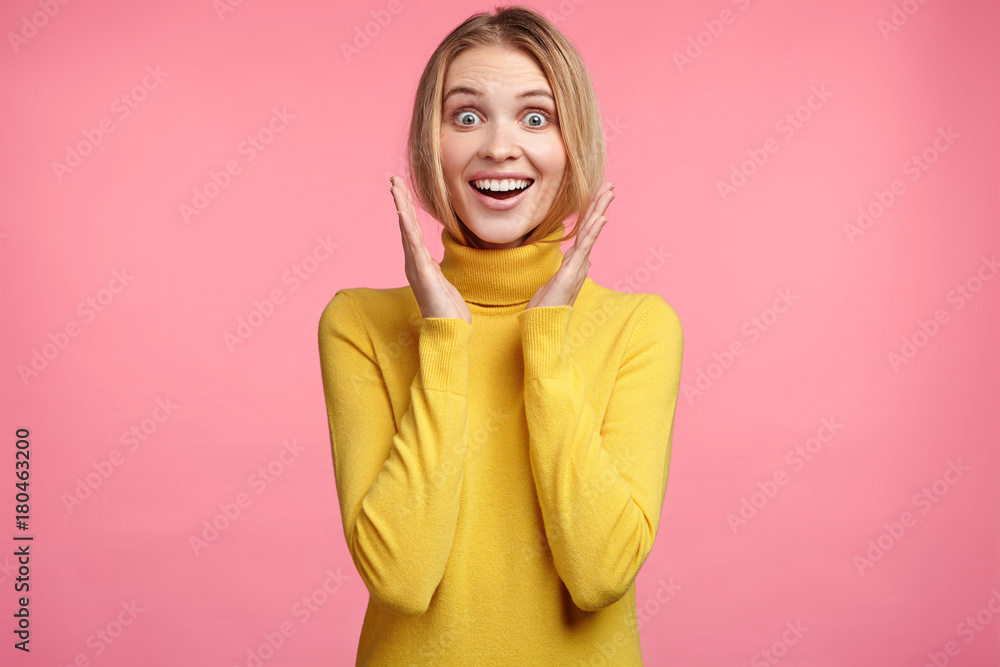 Excited blonde female smiles happily, gestures actively, rejoices her victory on competition, expresses positiveness. Joyful young woman glad to hear pleasant news about her promotion in work Excited blonde female smiles happily, gestures actively, rejoices her victory on competition, expresses positiveness. Joyful young woman glad to hear pleasant news about her promotion in work