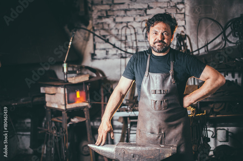 Fotografia The portrait of blacksmith preparing to work metal on the anvil