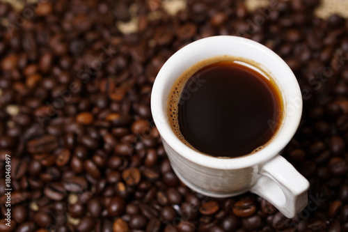 Cup of coffee on coffee beans