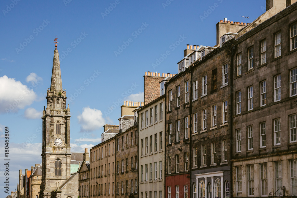 Looking up at a row of houses and church steeple in an Edinburgh (Scotland) street on a beautiful sunny day
