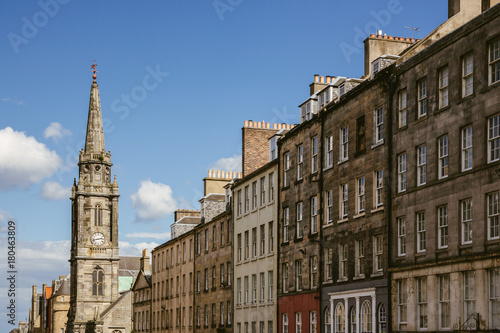 Looking up at a row of houses and church steeple in an Edinburgh (Scotland) street on a beautiful sunny day