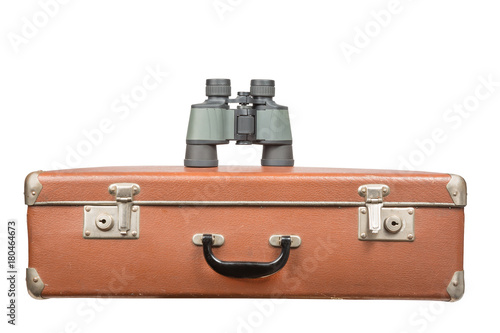 Travel and adventure concept. Vintage brown suitcase with binoculars isolated on white